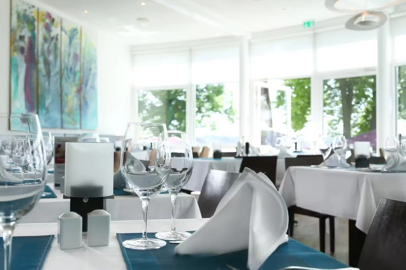 Gedeckte Tische im lichtdurchfluteten Speisesaal des Restaurant Hessenwinkel in Berlin-Köpenick